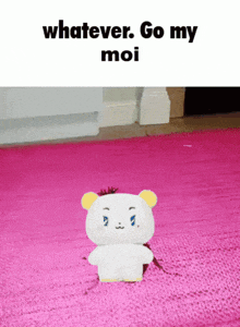 a stuffed teddy bear on a pink rug with the words whatever go my moi on the bottom