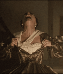 a woman in a striped dress is screaming with her mouth wide open