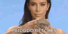 a woman is holding a bunch of money in her hands and making a funny face .