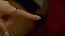 a woman is holding another woman 's hand while wearing a ring on her finger .
