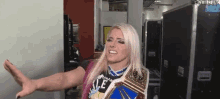 a woman is wearing a wrestling championship belt while standing in a room .