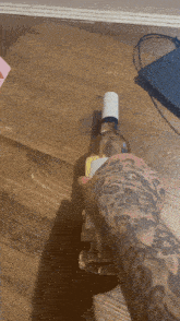 a person with a tattoo on their arm is holding a bottle of wine