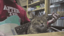 a cat playing a guitar with a person wearing a shirt that says after ten