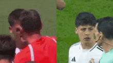 a man in a red shirt and a man in a white adidas shirt are standing next to each other on a field .