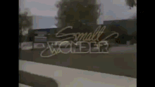 a small wonder sign is displayed in a blurry photo