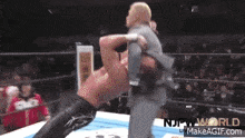 a man in a suit is being lifted up by another man in a wrestling ring