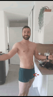 a shirtless man with a beard is standing in a kitchen with his arms outstretched ..