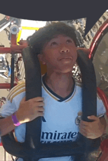 a man wearing a mirate shirt is riding a roller coaster