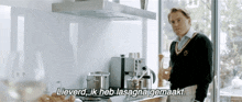 a man is standing in a kitchen and says " lieverd "