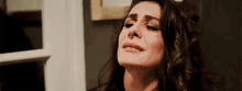 a woman with long hair is crying with her eyes closed .