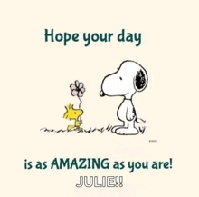 snoopy and woodstock are standing next to each other in a field .