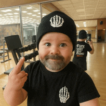 a baby with a beard wearing a black shirt that says flick what they doing