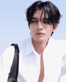 a man wearing a white shirt and a black bag
