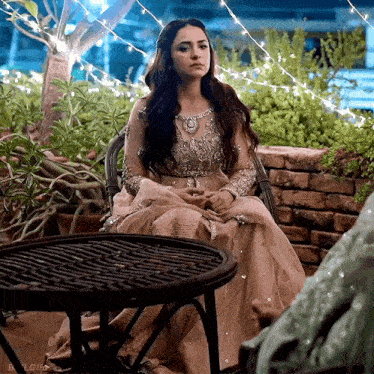 a woman in a dress is sitting at a table .