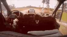 a person is driving a car on a road with a bottle of water on the dashboard