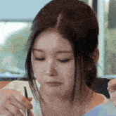 a close up of a woman eating food with a knife and fork