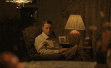a man sitting in a chair with the words you guys kiss each other on the lips below him