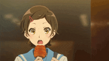 a girl with a red clip in her hair is eating a piece of food