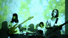 a woman playing a guitar and a man playing a drum
