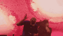a man in a blue shirt stands in front of a red background