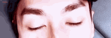 a close up of a person 's face with their eyes closed .