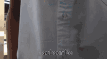 a close up of a white shirt with the words subscribe on it