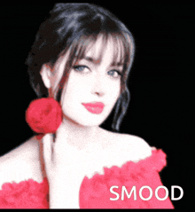 a woman in a red dress is holding a red rose in her hand