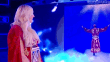 a woman in a red cape is standing next to a man in a red robe on a stage .