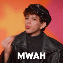 a person wearing a leather jacket and a hat with the word mwah written on it