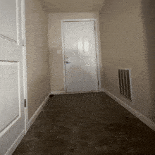 a hallway with a white door and a gray floor