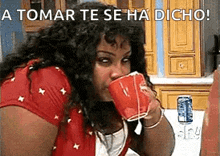 a woman drinking from a red cup with the words a tomar te se ha dicho