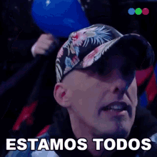a man wearing a baseball cap says " estamos todos "