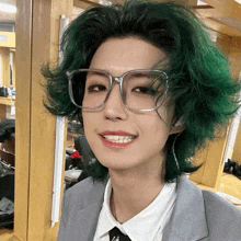a woman with green hair and glasses is smiling