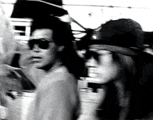 a black and white photo of a man and a woman standing next to each other .