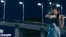 a woman holding a whip in front of a sign that says vespa gifs
