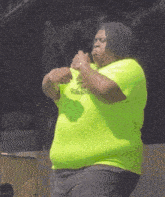 a man wearing a neon green shirt that says ' t.b. ' on it