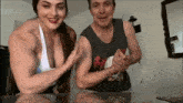 a man and a woman flex their muscles in front of a bro.tv logo