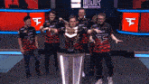 a group of people holding a trophy with the letter f on their shirt