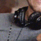 a close up of a person wearing headphones and a chain around their neck