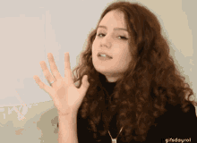 a woman with curly hair is waving her hand with the gifsdayrol written below her