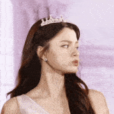 a woman is wearing a tiara and earrings