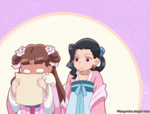 two girls are standing next to each other and one is holding a paper