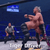 a wrestler named tiger driver is laying on the ground during a match
