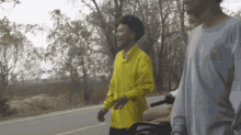 a man in a yellow shirt is walking down the street