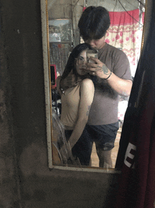 a man taking a picture of a woman in a mirror