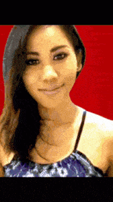 a woman with long hair is smiling in front of a red background