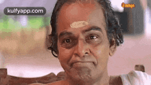 a man is making a funny face while sitting on a chair .