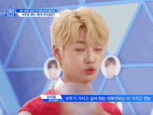 a boy with blonde hair is standing in front of a sign that says ' 101 ' on it