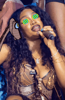 a woman is singing into a microphone with hypnotic eyes on her face