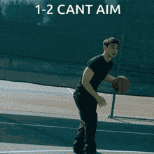 a man is holding a basketball over his head with the words 1-2 cant aim below him
